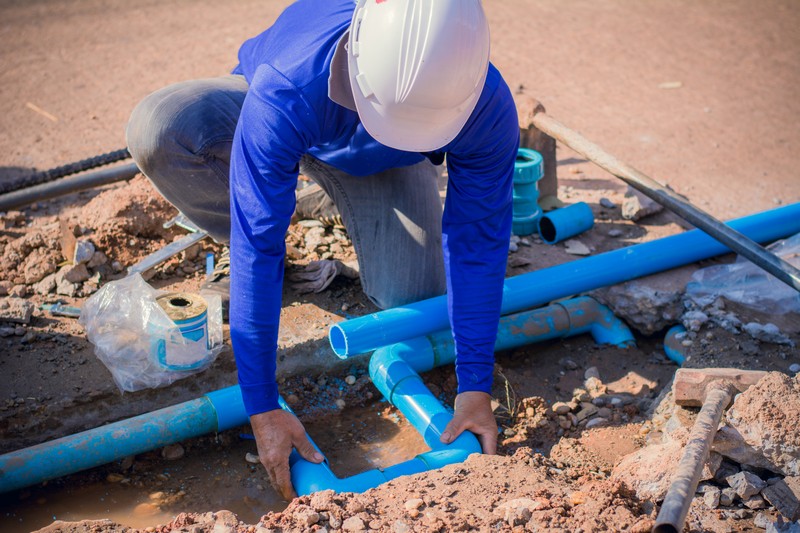 Construction,Worker,repairing,A,Broken,Water,Pipe,On,The,Concrete,Road.